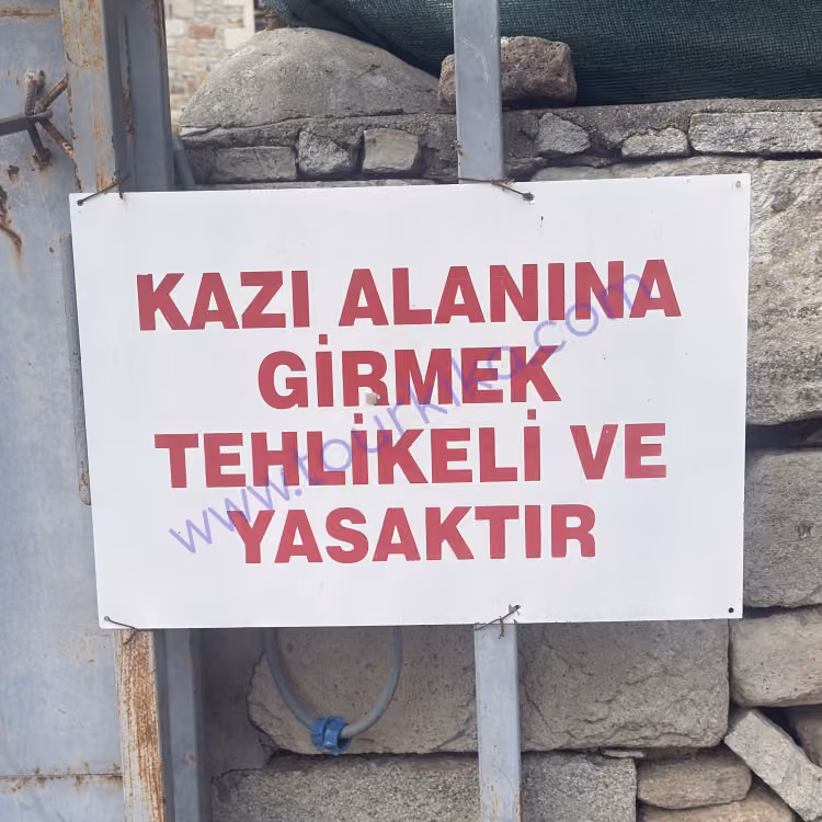 πινακίδα που γράφει στα τούρκικα Kazı alanına girmek tehlikeli ve yasaktır (Η είσοδος στον χώρο ανασκαφών είναι επικίνδυνη και απαγορεύεται)